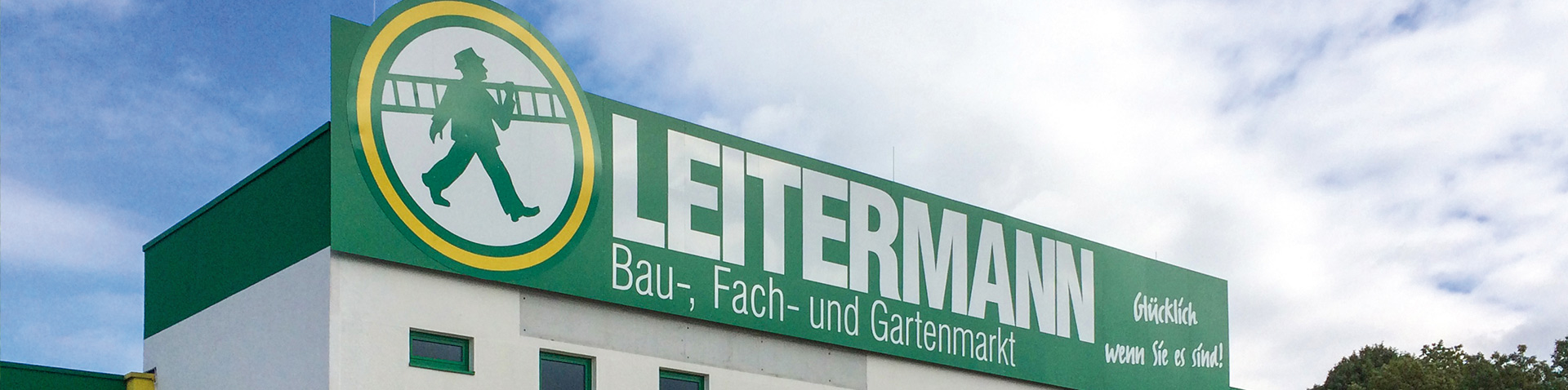 Grünes LEITERMANN-Schild mit Logo auf dem Dach eines Bau-, Fach- und Gartenmarkts – Leitermann Success Story