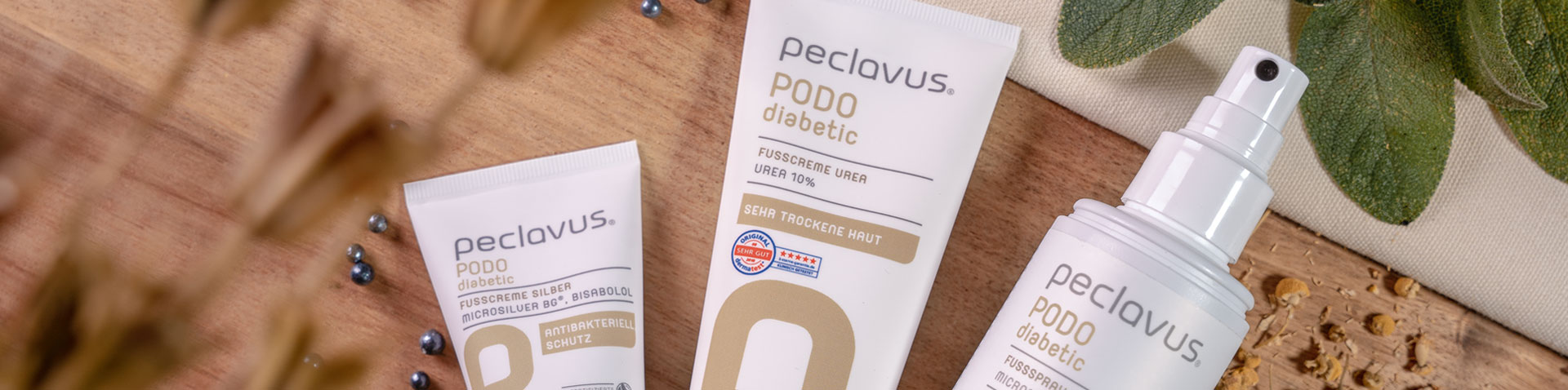 Foot creams and foot spray from the peclavus PODO diabetic range on a wooden board – peclavus success story