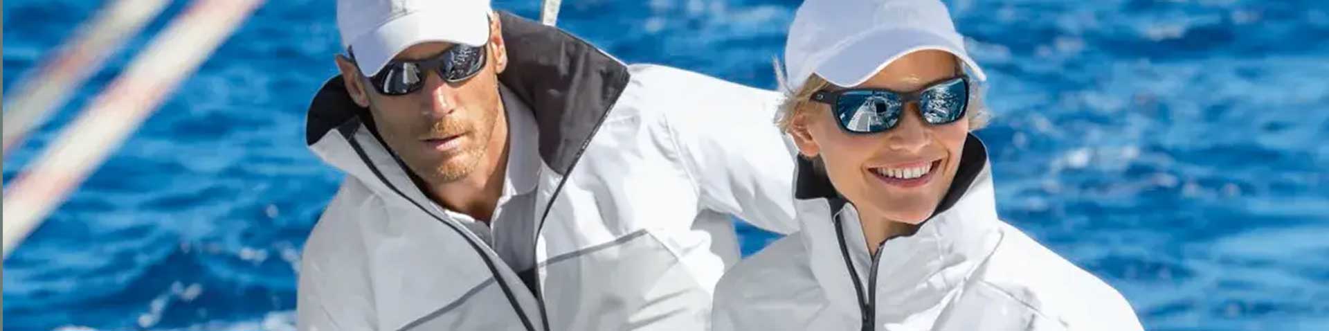 Mann und Frau in weißen Segeljacken mit Caps und Sonnenbrillen auf dem Meer – Compass und SEALAND24 Success Story