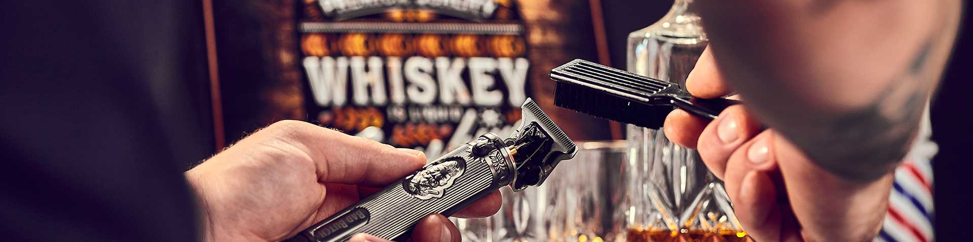 Hände halten einen Haarschneider und eine Reinigungsbürste, dahinter Whiskeyglas und Karaffe – EFALOCK Success Story