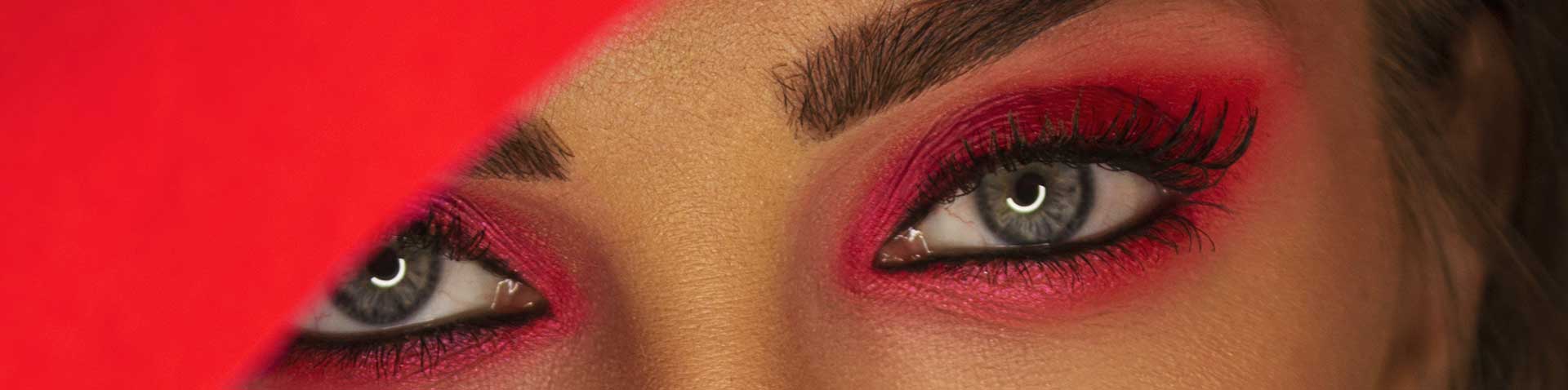 Red-painted eyes of a woman as a symbolic image for blog article "The role of PIM in the beauty industry"