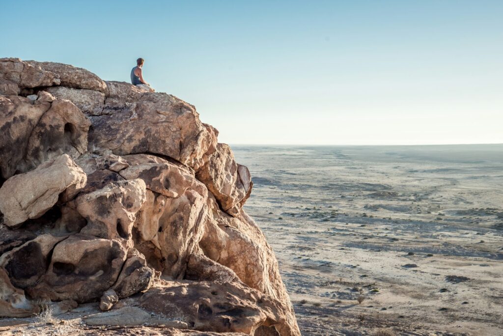 A man sitting on a mountain as a symbol of today's importance and the future of E-Commerce