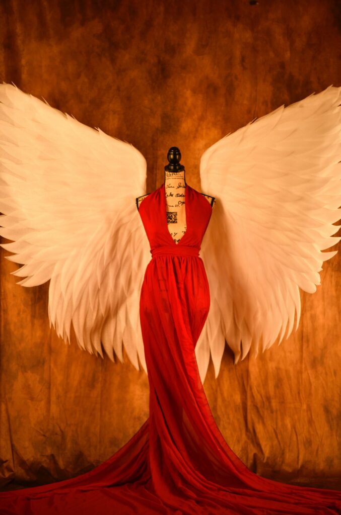 Red dress on a dress doll with angel wings as a symbolic image for blog Accessibility in e-commerce: How to make your online store legally compliant by 2025