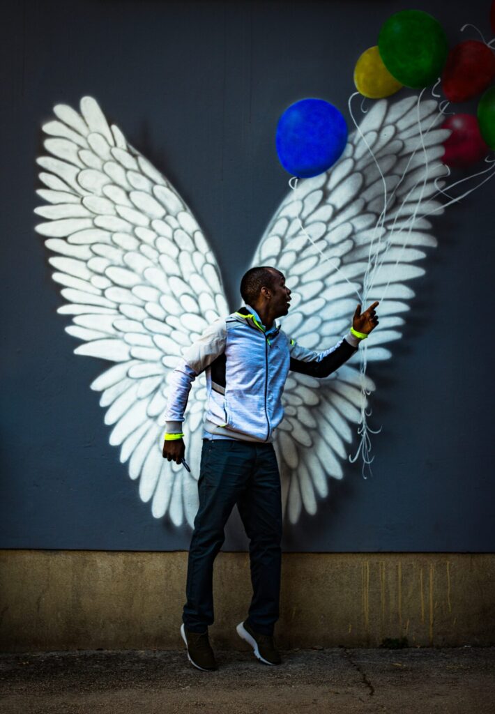 Man with angel wings and balloons in his hand as a symbolic image for blog articles Brief overview: Digital accessibility