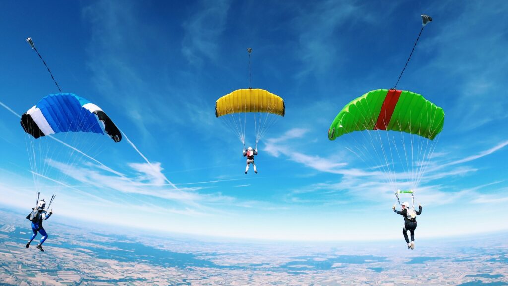 Three skydivers with open parachutes in the air as a symbolic image for blog articles Brand building in B2B