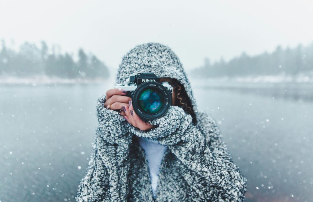 Woman with camera in winter for blog DAM and brand