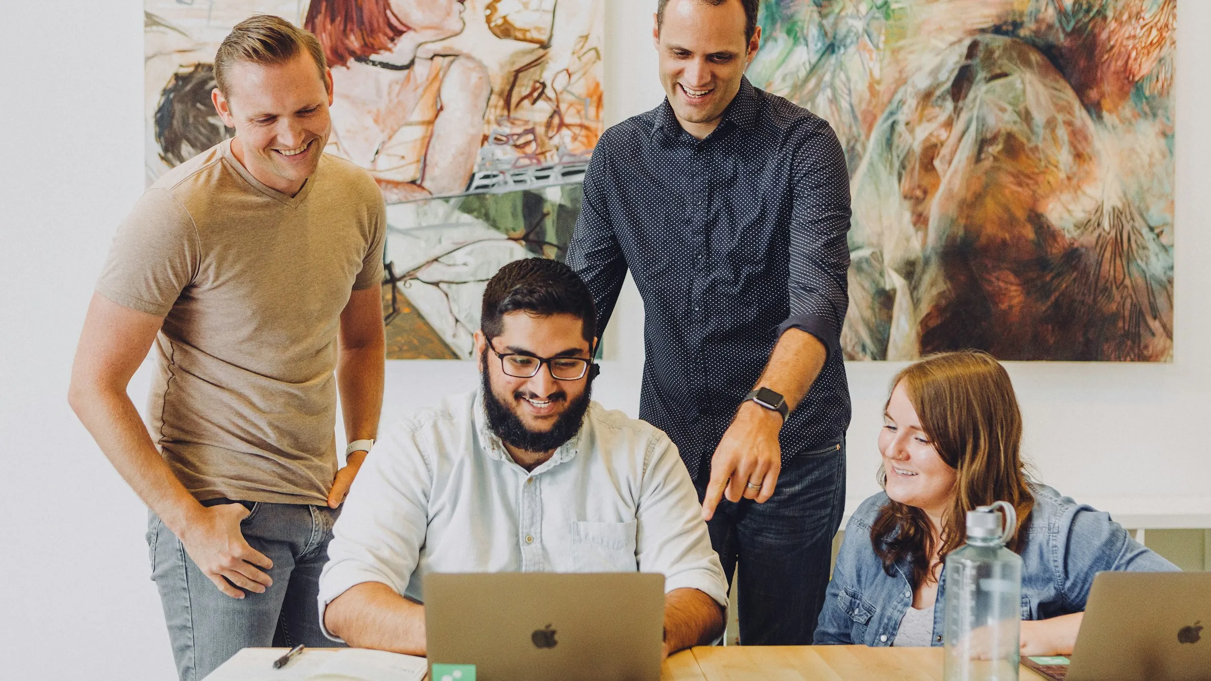 Team working together on a laptop — users of apollon Online Media Net
