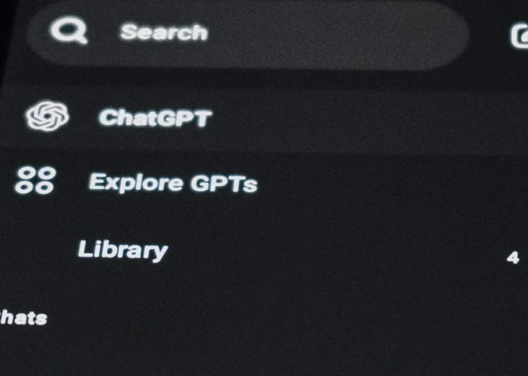 Chat-Oberfläche einer KI-Suche auf einem Smartphone über einer Laptop-Tastatur – Motiv zu GEO für Produktseiten