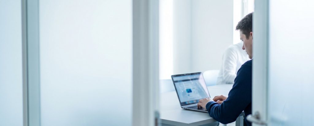 Person schreibt in einem ruhigen Raum vertraulich eine Meldung am Laptop