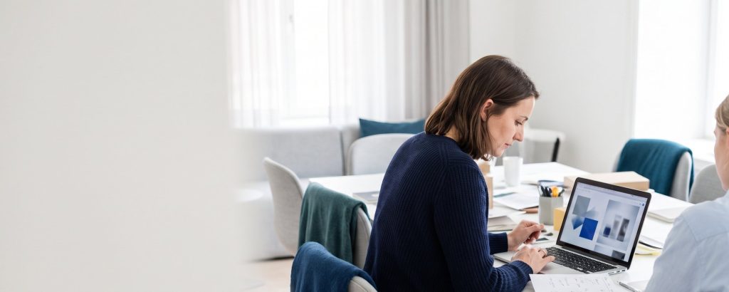 Texterin arbeitet mit einem KI-Schreibassistenten am Laptop