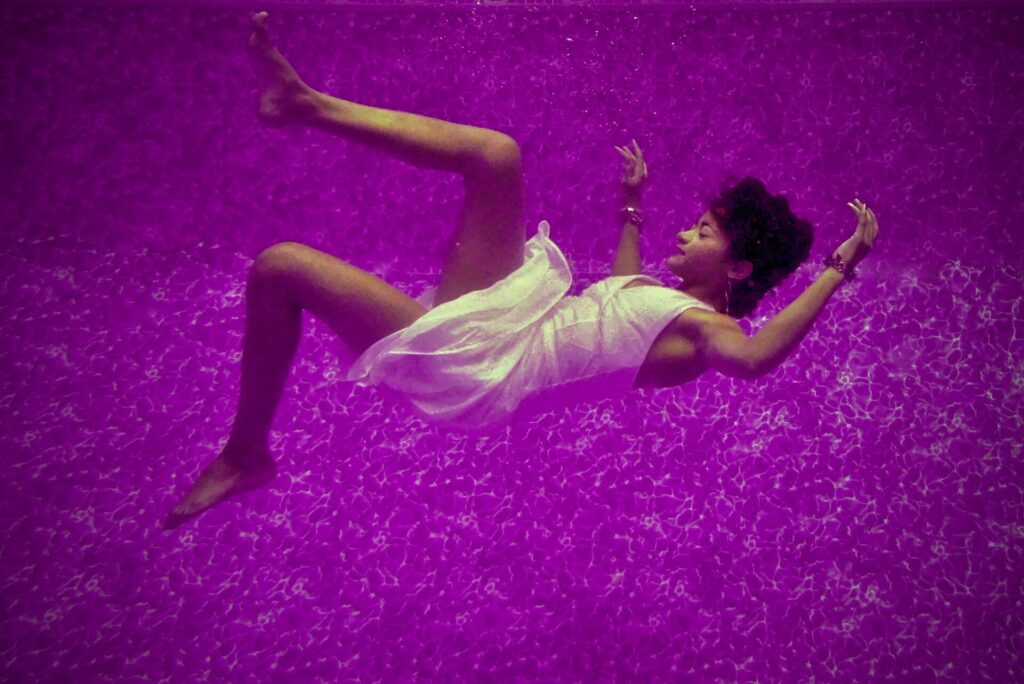 Frau, die in lila Wasser schwebt für Syndizieren