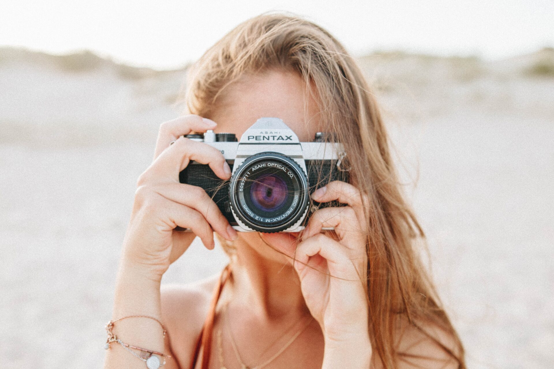 Frau mit Kamera vor dem Gesicht für Bereich Photography