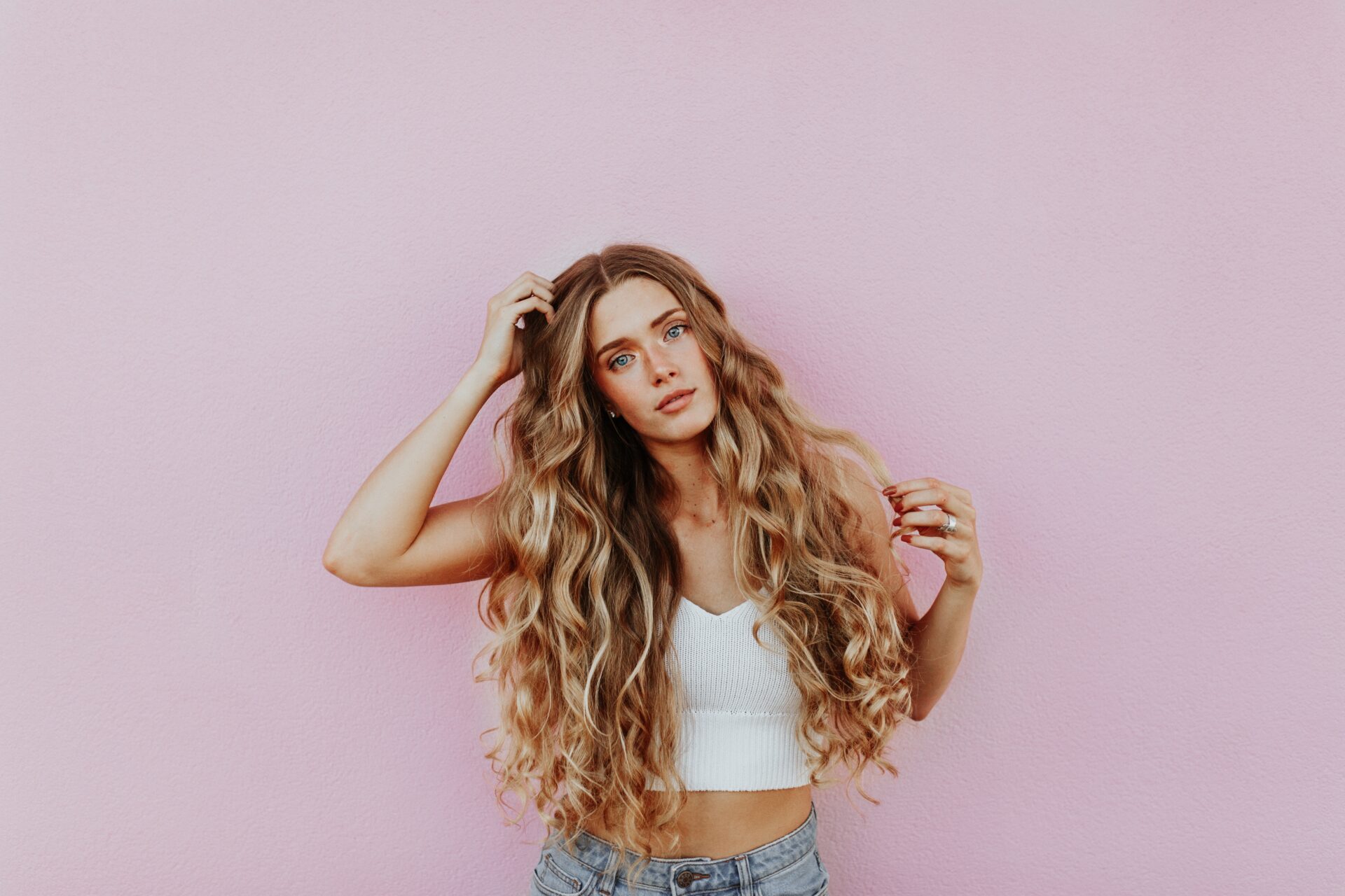 Blonde Frau vor rosa Wand für Bereich Success Stories