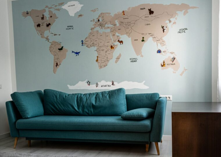 Wohnzimmer mit blauer Coach und Weltkarte an Wand