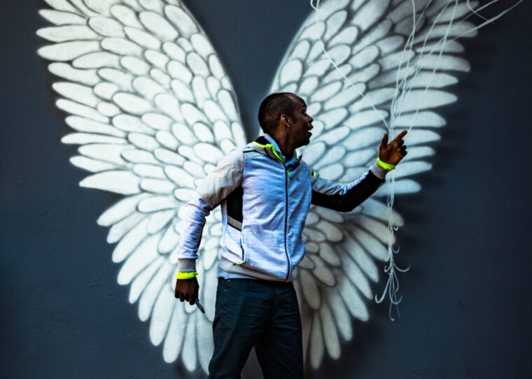 a man pointing at a mural