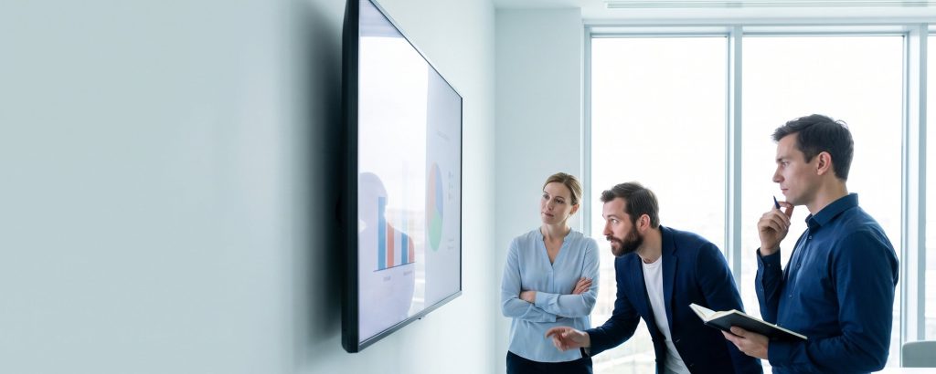 Team comparing software options on a large screen