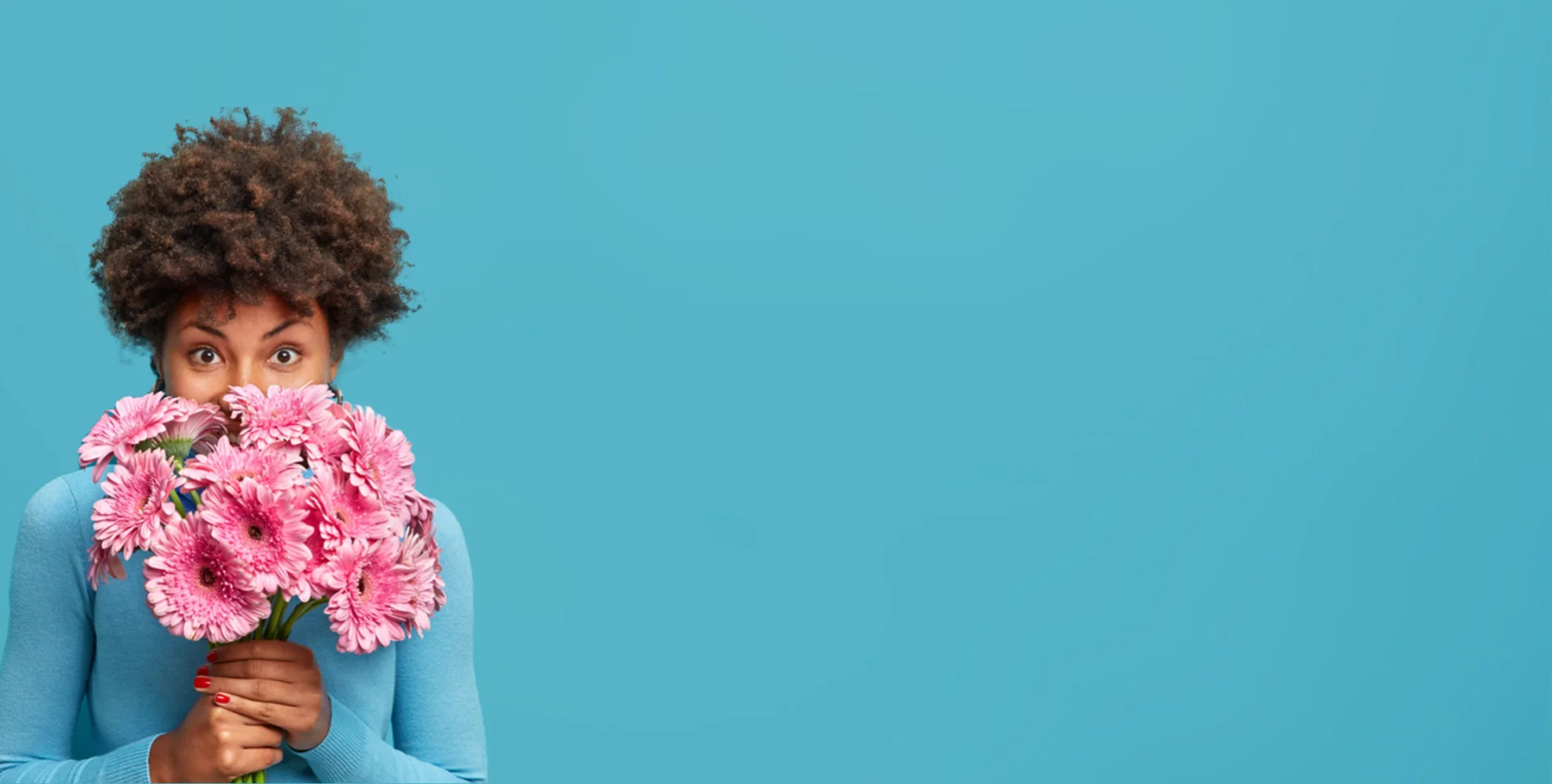 Frau mit rosa Blumenstrauß vor blauer Wand auf linker Seite