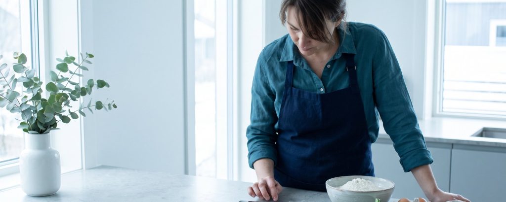 Ingredients on the counter, woman checking the recipe on a tablet